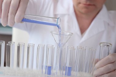 Erkek bir kimyager bilimsel bir laboratuvarda araştırma yapıyor. Seçici odak. 