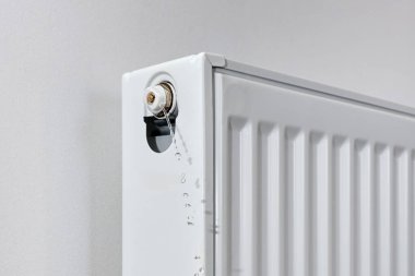 Radyatörde hava kanaması var. Bir apartmandaki radyatörden su ve hava emen bir tesisatçı..