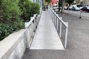 Girişteki tekerlekli sandalye kullanıcıları için büyük bir rampa. Kamu alanlarına ve sosyal açıdan önemli binalara rampa kurulması.