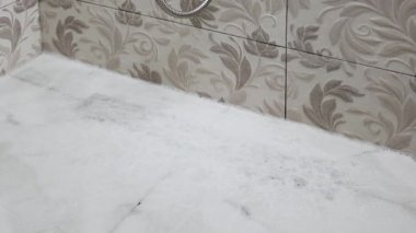 Duş kabinine sızan köpüğün üst görünümü.