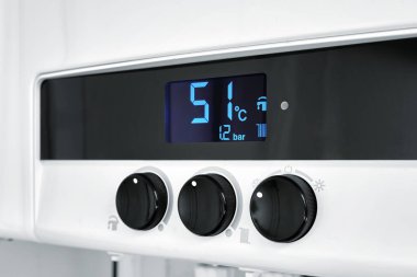 Yakın çekim düzenleyiciler modern bir dijital gaz kazanları. Merkezi ısıtma seviyesini gaz kazan paneline ayarlıyorum.