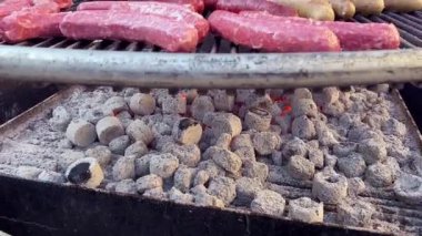 Dışarıdaki ızgarada farklı etlerden yapılmış büyük sosislere yakın çekim. Büyük bir grup insan için lezzetli yiyecekler..