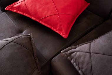 Alcantara 'dan yapılmış bir kanepenin üst görüntüsü suni deri, güzel siyah ve kırmızı yastıklar..