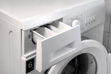 Çamaşır odasında çamaşır makinesinde bulaşık yıkamak için açık konteynır ya da jel. Seçici odak.