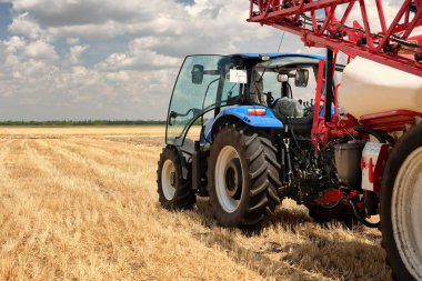 Tarlalara gübre ya da su püskürtmek için karavan tarımsal ekipmanlı traktörün arka görüntüsü. Hasattan sonra ekime başlayın. Tarımsal ekipman işi.