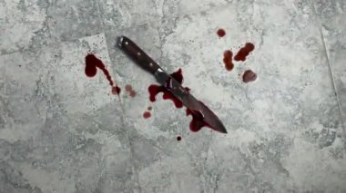 Üst manzara fayanslarla döşenmiş ev mutfağında kanlı bir bıçak. Evde şiddet, evlilik..