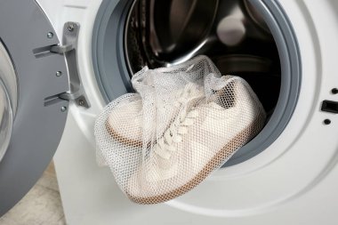 Çamaşır torbasındaki spor ayakkabılarını açık davulla çamaşır makinesine koy..