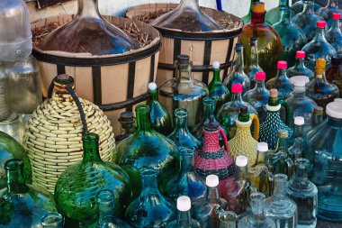 Ev yapımı şarap doldurmak için çeşitli renkli cam şişeler ve sürahiler. Gürcü şarap yapma geleneği. Seçici odak.