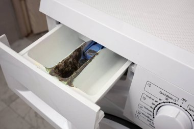 Deterjan konteynırındaki toprak ve küfün yakın plan görüntüsü. Çamaşır makinesinin bakımsızlığı ve bakımı.