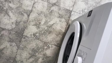Köpüklü su çamaşır makinesinin altından yere akar..