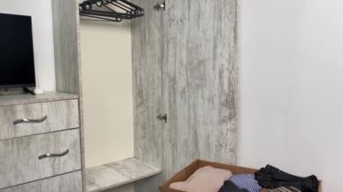 Arka planda boş bir elbise dolabı olan iki karton kutu..