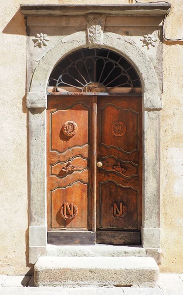 Old solid wood door in the village of Pigna, in Balagne, on the famous island of Corsica, in the Mediterranean Sea. Surrounded by olive trees, this charming village is a haunt of artists and craftmen