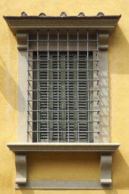 beautiful old window protected with bars in an alley of Florence, capital of Tuscany in Italy