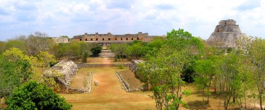 Antik Maya şehri Uxmal, Yucatan, Meksika 'nın panoramik manzarası, ön planda top sahası, arka planda rahibelerin dörtgeni ve sağda Kahin Piramidi.