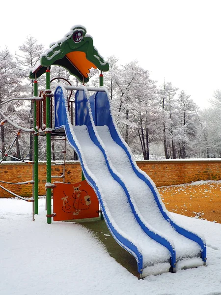 abandoned playground for children under the snow in the gardens of the town hall of Montargis, nicknamed the Venice of Gatinais, sub-prefecture of the Loiret department, in the Center-Val-de-Loire region