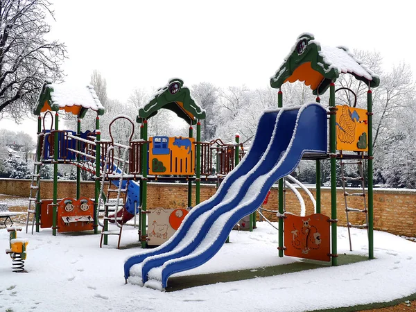 abandoned playground for children under the snow in the gardens of the town hall of Montargis, nicknamed the Venice of Gatinais, sub-prefecture of the Loiret department, in the Center-Val-de-Loire region