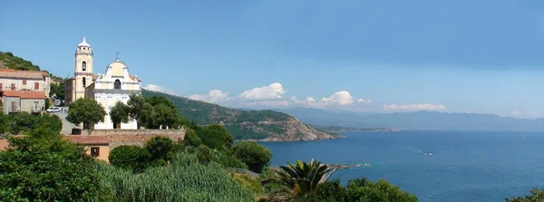 在科西嘉岛西海岸的地中海上 希腊村 Cargese 占据了主导地位 这个岛的绰号叫 美丽岛 Island Beauty 这是一个了不起的村庄 因为它有两个教堂 — 图库照片