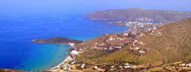 Agios Petros sahilinin panoramik manzarası ve Andros 'taki Gavrio körfezi, Ege Denizi' nin merkezindeki ünlü bir Cyclades adası.