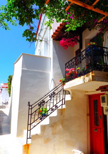 One of the charms of Andros, Greek island in the heart of the cyclades, are its narrow streets : white houses with small flowered balconies touching almost above paved streets