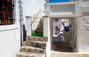 Sikladların merkezindeki Yunan adası Andros 'un cazibelerinden biri dar sokaklarıdır: küçük çiçekli balkonları neredeyse asfalt sokakların üzerine dokunan beyaz evler