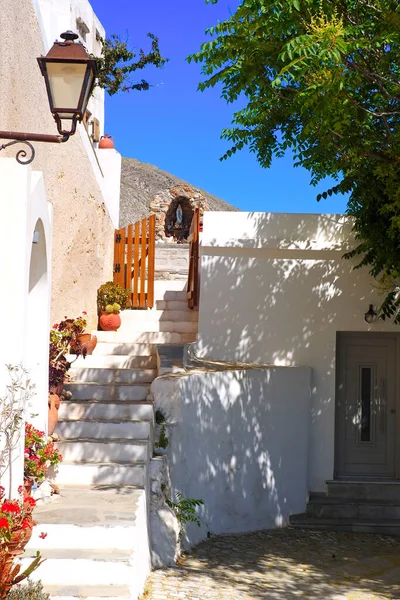 stock image One of the charms of Mykonos, Greek island in the heart of the cyclades, are its narrow streets : white houses with small flowered balconies touching almost above paved streets