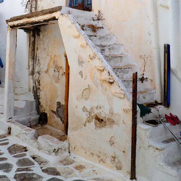 エーゲ海の中心部にあるキクラデス諸島の魅力の1つは 白い家が並ぶ狭い通りで 石畳の階段と小さな花のバルコニーがあります — ストック写真