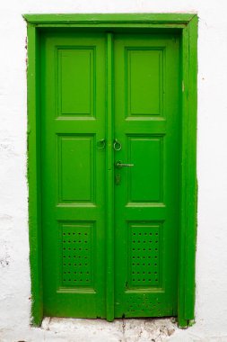  the old and solid painted wooden doors are one of the charms of the magnificent Cyclades islands, in the heart of the Aegean Sea  clipart