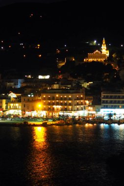 Ege Denizi 'nin göbeğinde, Panaghia Evangelistria Kilisesi' nin egemen olduğu muhteşem bir Cyclades takımadası adası olan Tinos limanının (Yunanistan) gece manzarası