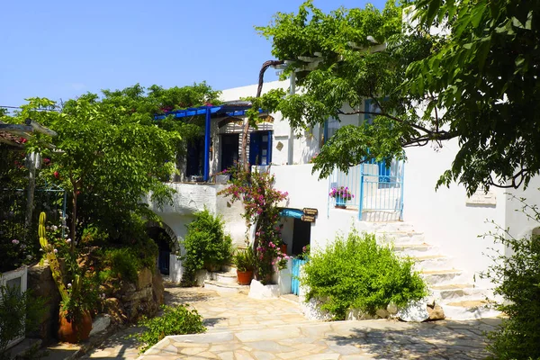 stock image One of the charms of the Cyclades islands (here in the village of Volax, on the island of Tinos in Greece), in the heart of the Aegean Sea, are the narrow streets lined with white houses with their cobbled stairs and small balconies flowery