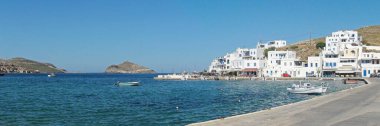 Körfezin panoramik manzarası, Nisis Planitis adası ve Tinos adasında beyaz bir köy olan Panormos limanı, Ege Denizi 'nin göbeğindeki büyüleyici Cyclades adası.