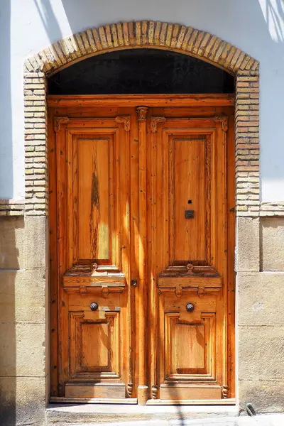 Old solid wooden door of a house in Pamplona, a large and beautiful Spanish city in the province of Navarre, neighboring the Basque Country