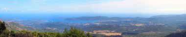panoramic view of the eastern coast of Corsica, nicknamed the Isle of Beauty, from the charming belvedere village of Prunelli. We see a large part of the plain, the island of Elba and Montecristo. On a clear day mainland Italy can be seen clipart