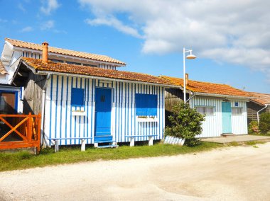Audenge 'de, Gironde' deki Arcachon Havzası 'nda (Nouvelle-Aquitaine) büyüleyici bir köy olan kabinler, 19. yüzyılın sonunda istiridye çiftçileri tarafından limana inşa edildi ve birçok renge boyandı.