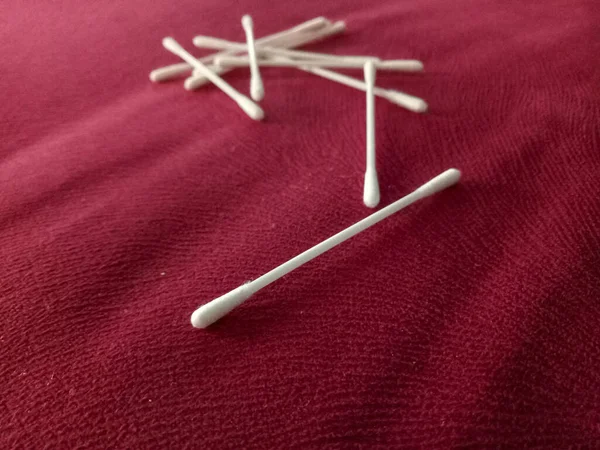 Disposable cotton swabs isolated on a red background