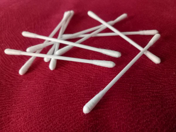 Disposable cotton swabs isolated on a red background