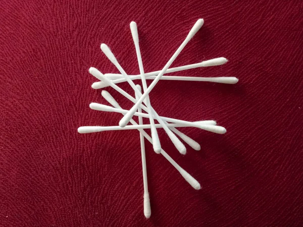 Disposable cotton swabs isolated on a red background
