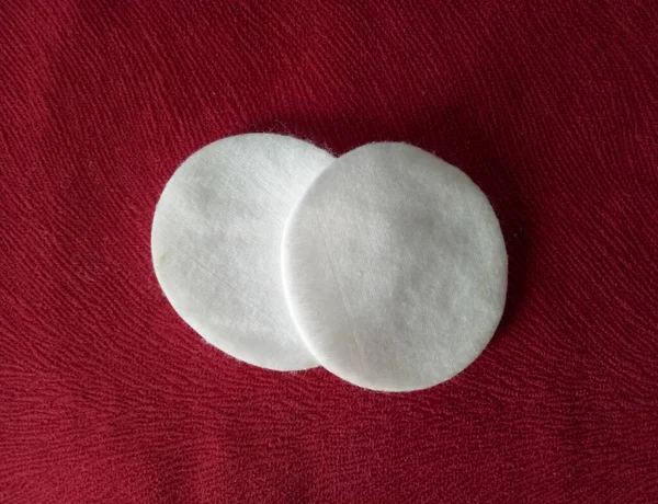 Facial cotton pads isolated on red background
