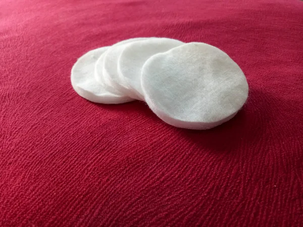 Facial cotton pads isolated on red background