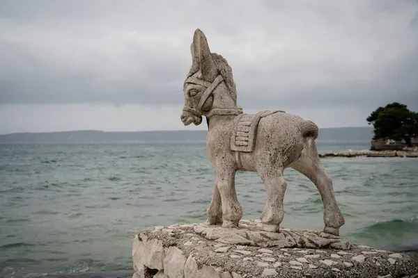 Uma Escultura Pedra Resistida Burro Fica Cais Costeiro Com Fundo — Fotografia de Stock