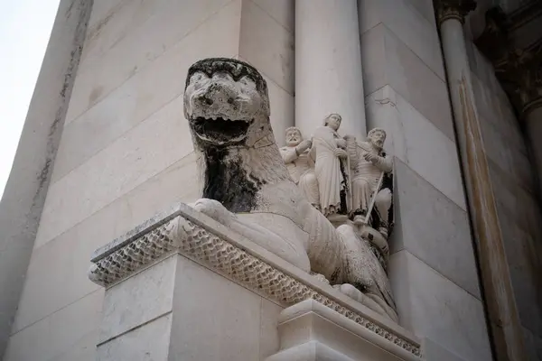 一座典雅的历史建筑装饰着一座石狮雕塑 其背景上有详细的人物形象浮雕 — 图库照片