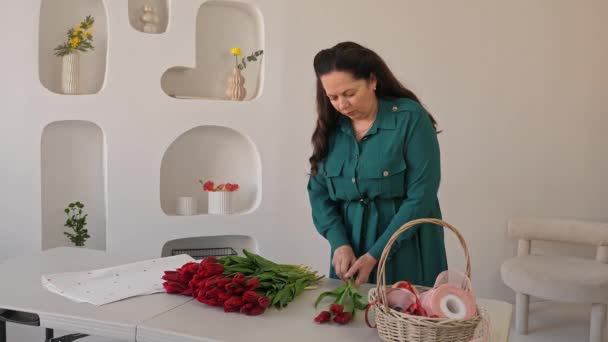 女人把红色的郁金香排序成大而浓郁的花束 专业制造新鲜的花束 小商业 — 图库视频影像