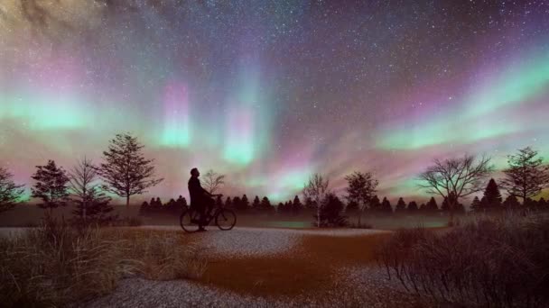 Nordlichter Bewegen Sich Sternenhimmel Mit Einem Mann Auf Einem Fahrrad — Stockvideo
