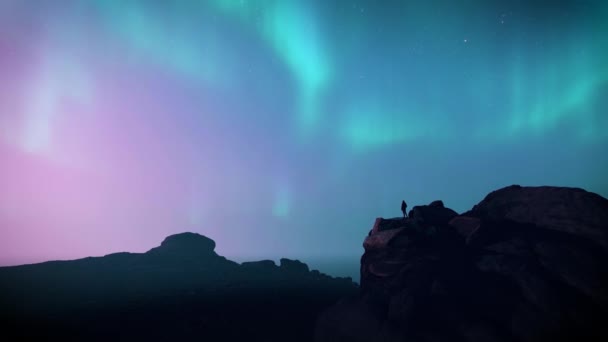 Polarlichter Bewegen Sich Rosa Und Blauem Nachthimmel Über Einem Silhouettenwanderer — Stockvideo