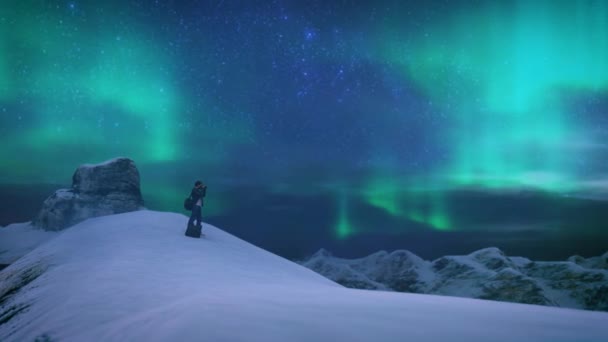 3D动画 站在白雪覆盖的山顶上的男性游客 在星空拍摄明亮的北极光 — 图库视频影像