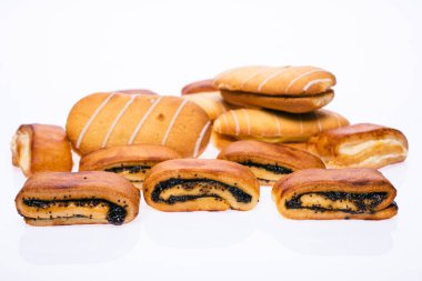 Delicious sweet buns with jam and poppy seeds. And cream pies. On a white isolated background.