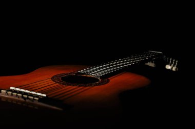 Guitar. Classical acoustic guitar. On an isolated black background. Place for text. Close-up studio photography with fine details.