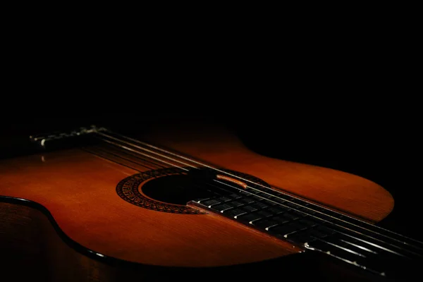 Guitar. Classical acoustic guitar. On an isolated black background. Place for text. Close-up studio photography with fine details.