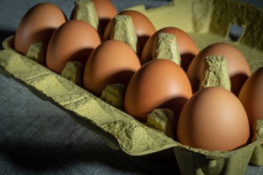 Yumurta kutusundaki tavuk yumurtalarının detaylı görüntüsü. Doğal kumaşın üzerine yatarlar..
