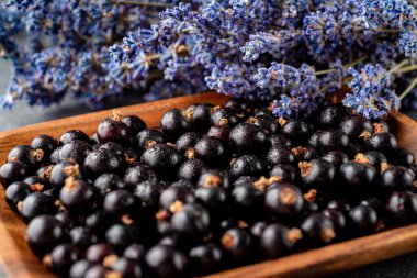 Frenk üzümü ve su damlası. Etrafı lavanta çiçekleriyle çevrili. Pek çok küçük detay ile yakın çekim. Duvar kağıdı, harika arkaplan.