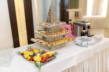 Çikolata. Piramit şeklinde çok aşamalı platformda çeşitli parlak tatlılar.